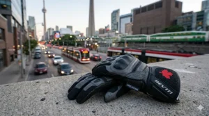 A motorcyclist in Toronto city traffic wearing lightweight summer gloves for daily commuting.