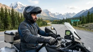 A rider navigating a scenic, gravel mountain pass in the Canadian Rockies wearing armored adventure motorcycle gloves for grip and protection.