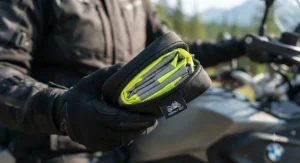 Foldable reflective vest for motorcycle riders packed compactly into an integrated storage pouch.