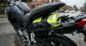 Compact and packable motorcycle rain gear stored in a waterproof storage bag under the motorcycle seat.