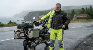 Men putting on a lightweight budget motorcycle rain suit before a long-distance touring ride in Atlantic Canada.