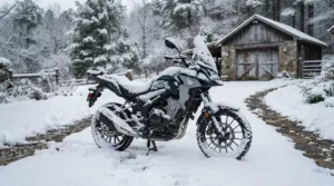 A motorcycle cover for outdoor winter storage protecting a cruiser parked on a snow-covered driveway during a Canadian winter.