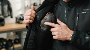 Inspecting the CE-rated armour inside a textile vs leather motorcycle jacket for spring riding.