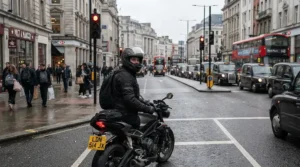A commuter stuck in morning traffic deciding on a textile vs leather motorcycle jacket for spring riding.