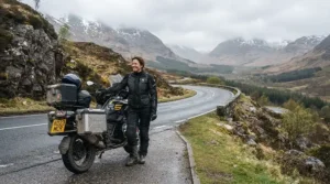 A rider evaluating a textile vs leather motorcycle jacket for spring riding along a winding Canadian mountain highway.